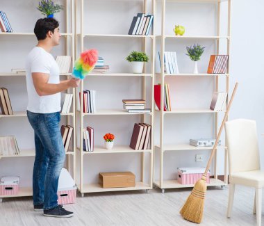 Adam evi temizliyor.