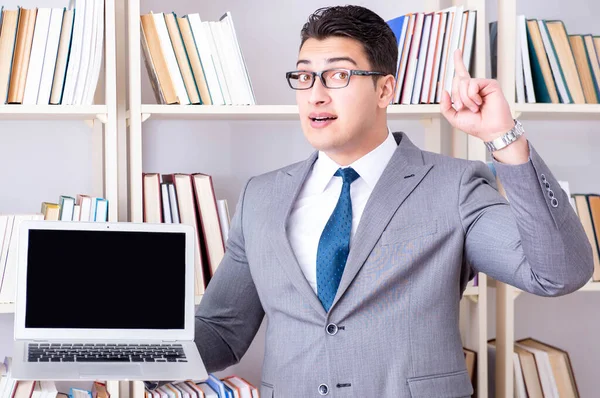 Kütüphanede çalışan boş ekran bilgisayarı olan bir iş adamı.