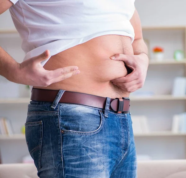 Diyet konseptinde fazladan ağırlık çeken adam.