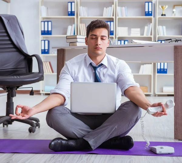 Людина медитує в офісі, щоб впоратися зі стресом — стокове фото