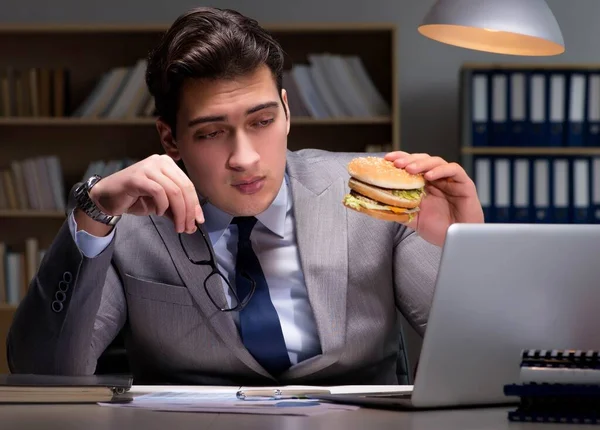 Geschäftsmann spät in der Nacht einen Burger essen — Stockfoto