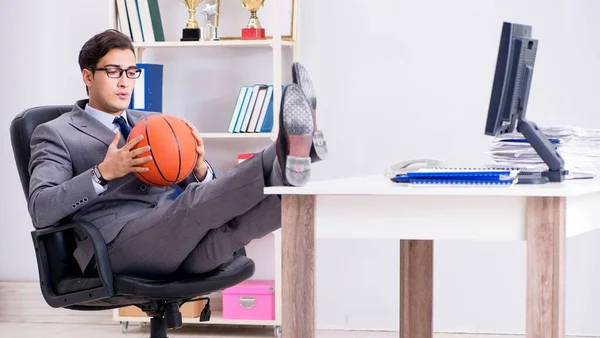 Jovem empresário jogando basquete no escritório durante o intervalo — Fotografia de Stock