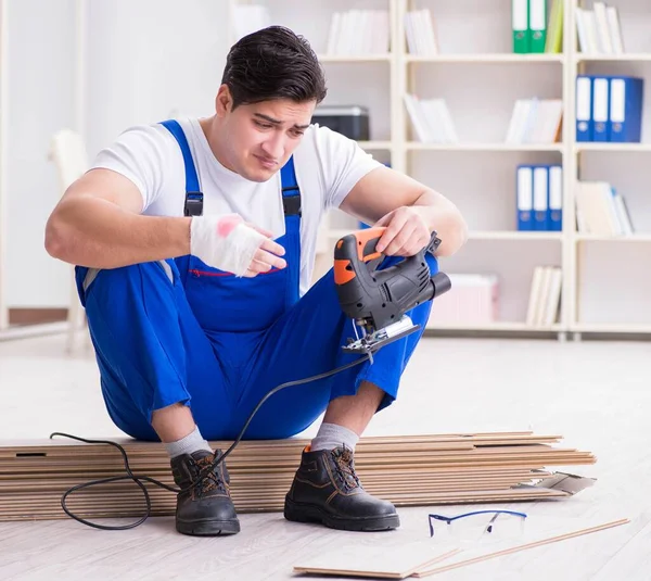 Giovane lavoratore che lavora su pavimenti in laminato — Foto Stock