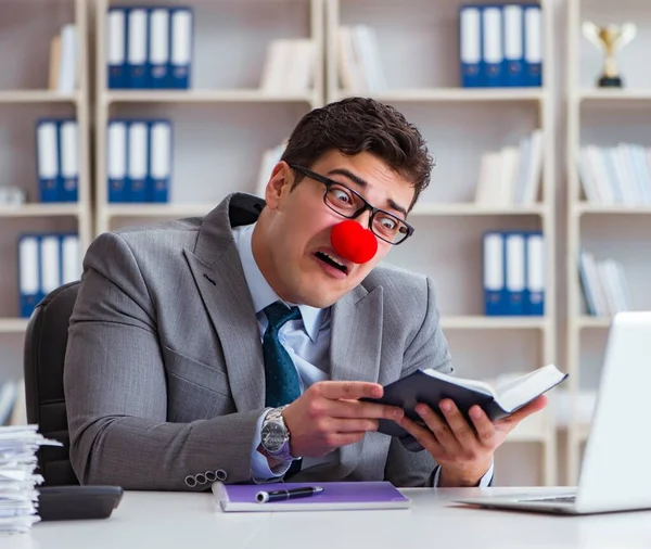 Ofiste çalışan palyaço işadamı.