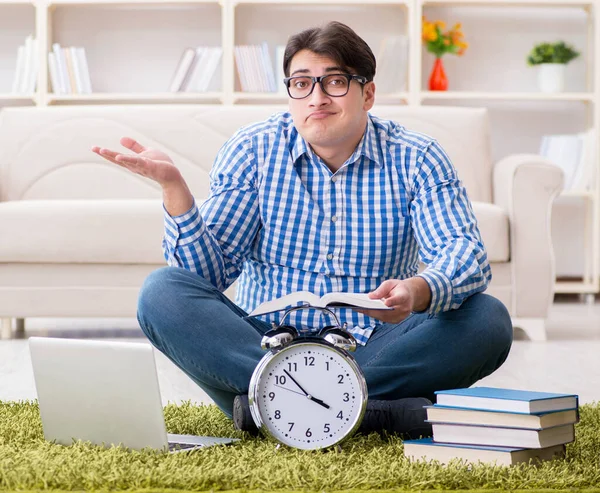 Genç yakışıklı adam evde yerde oturuyor.