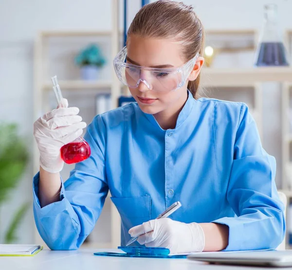 Bir laboratuarda deney yapan kadın bir bilim adamı.