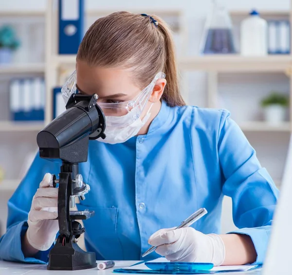 Bir laboratuarda deney yapan kadın bir bilim adamı.