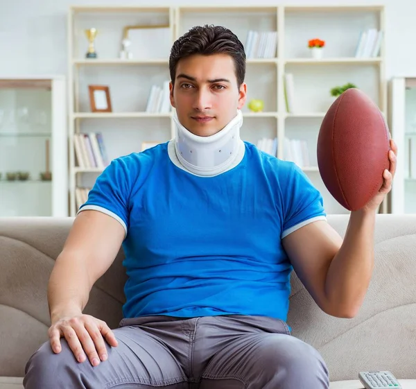 Homem com lesão no pescoço assistindo futebol americano em casa — Fotografia de Stock