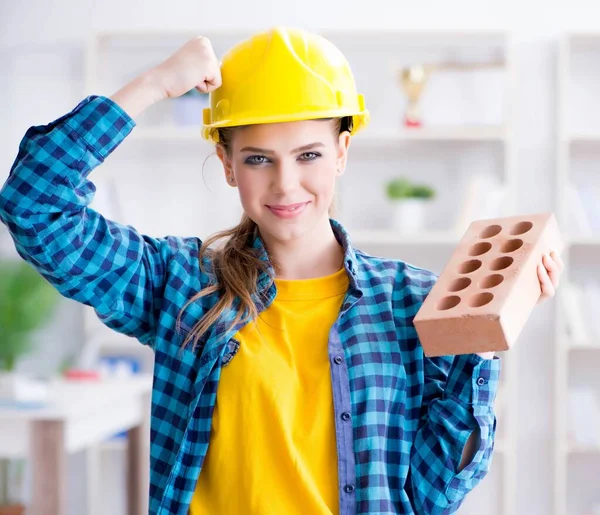 La mujer con ladrillo en concepto de construcción — Foto de Stock