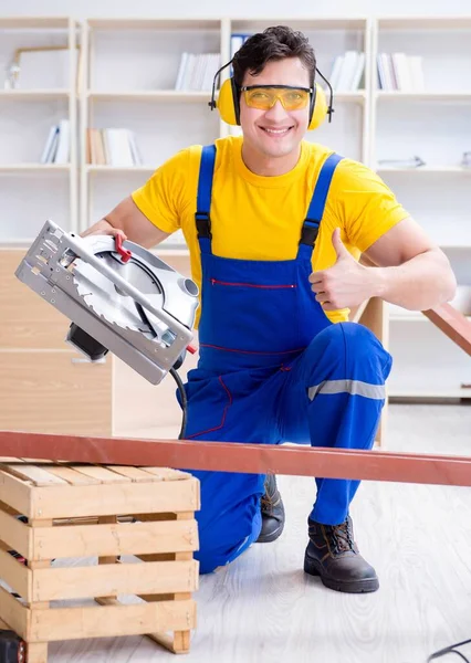 Reparador carpintero cortando aserrar una tabla de madera con un circuito — Foto de Stock