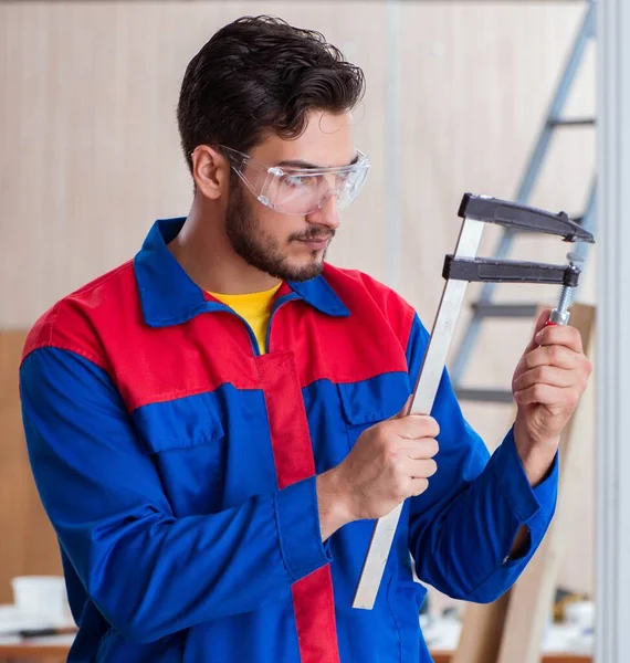 Genç tamirci marangoz kıskaçlarla çalışıyor.