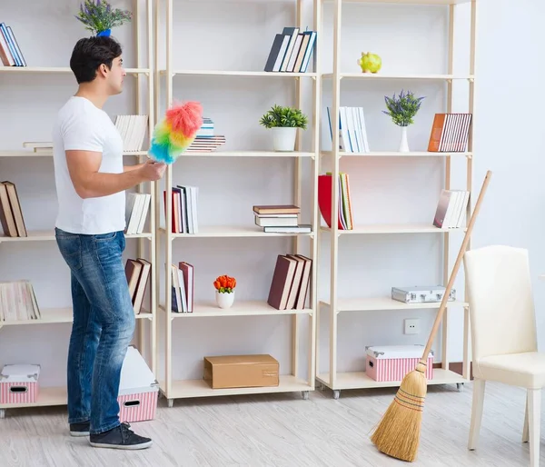 Adam evi temizliyor.