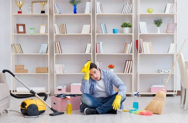 Adam evi temizliyor.