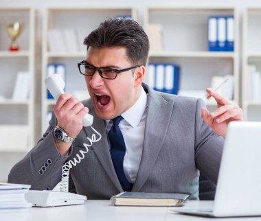 İşadamı ofisinde sigara içiyor.