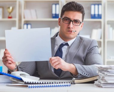 Ofiste sigara içen bir iş adamı elinde boş bir mesaj tutuyor.