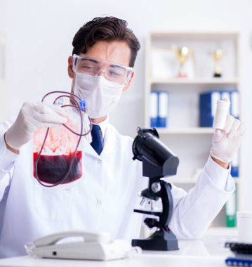 Hastane kliniğinde kan örnekleriyle çalışan bir doktor.