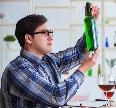 Profesyonel şarap garsonu kırmızı şarap tadıyor.