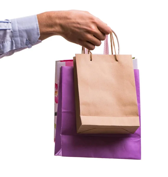Mano sosteniendo bolsas de compras con compras de Navidad en la espalda blanca — Foto de Stock