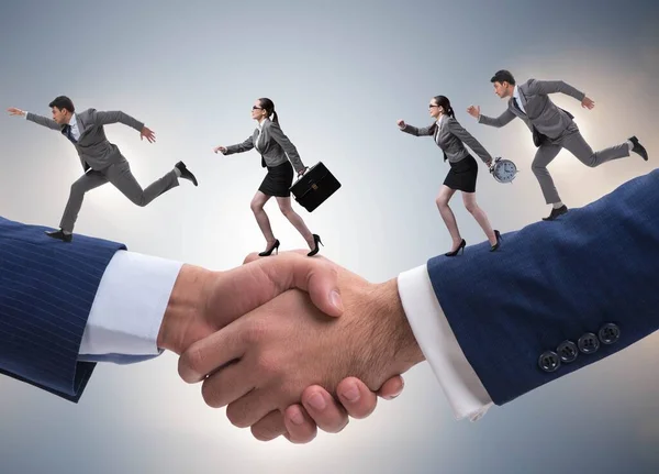 Cooperation concept with people running on handshake — Stock Photo, Image