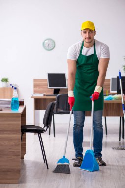 Genç müteahhit ofisi temizliyor.
