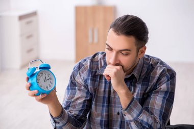 Genç erkek saatçi atölyede çalışıyor.