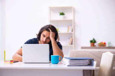 Evden çalışan genç bir adam.