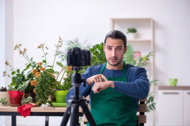 Evin içinde bitkileri olan genç bir erkek bahçıvan.