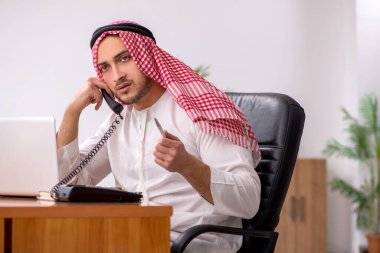 Ofiste çalışan genç bir Arap erkek.