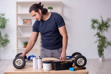 Kaykay tamir eden genç bir erkek tamirci.