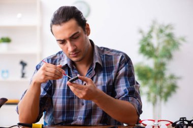Cep telefonunu tamir eden genç bir teknisyen.