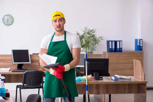 Jonge mannelijke aannemer schoonmaken van het kantoor — Stockfoto