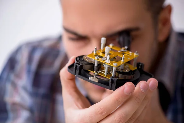 Giovane orologiaio maschile che lavora in officina — Foto Stock