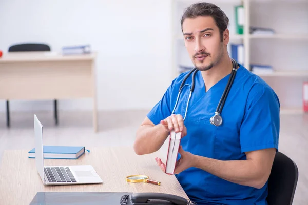 Mladý mužský lékař pracující na klinice — Stock fotografie