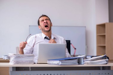 Genç bir erkek işçi aşırı işten memnun değil.