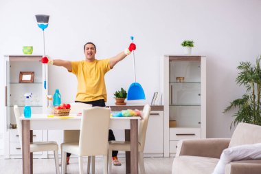 Genç erkek müteahhit evi temizliyor.