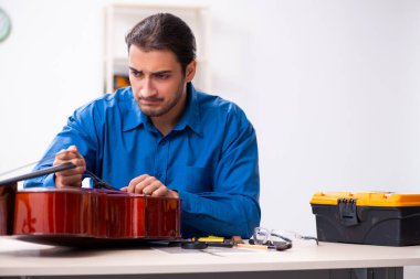 Genç erkek çello tamircisi.