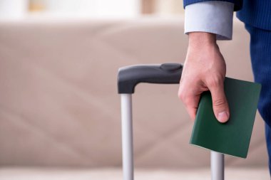 Pasaportlu genç işadamı seyahate hazırlanıyor.