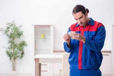 Genç erkek marangoz içeride çalışıyor.