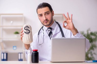 Klinikte çalışan genç erkek doktor.