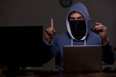 Erkek bilgisayar korsanı, güvenlik duvarını geç saatlerde hackliyor.