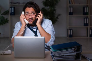 Genç işadamı ofiste geç saatlere kadar çalışıyor.