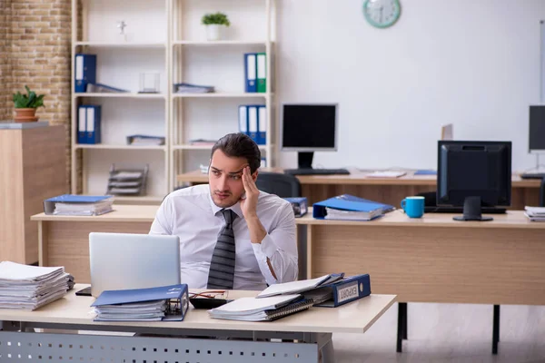 Giovane dipendente maschio infelice con il lavoro eccessivo — Foto Stock