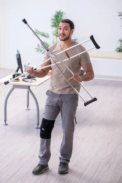 Young leg injured man with crutches — Stock Photo, Image