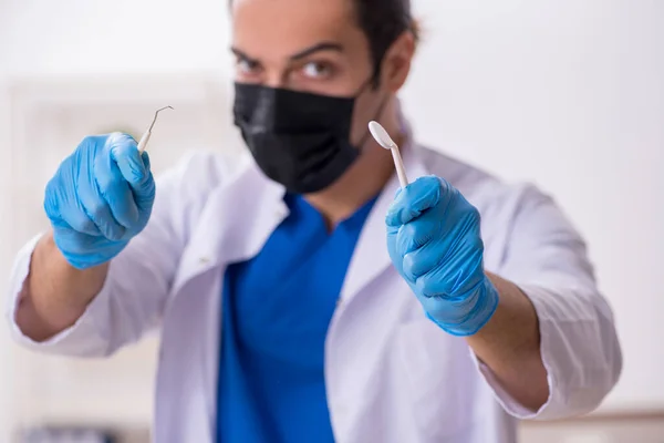 Jovem dentista do sexo masculino que trabalha na clínica — Fotografia de Stock