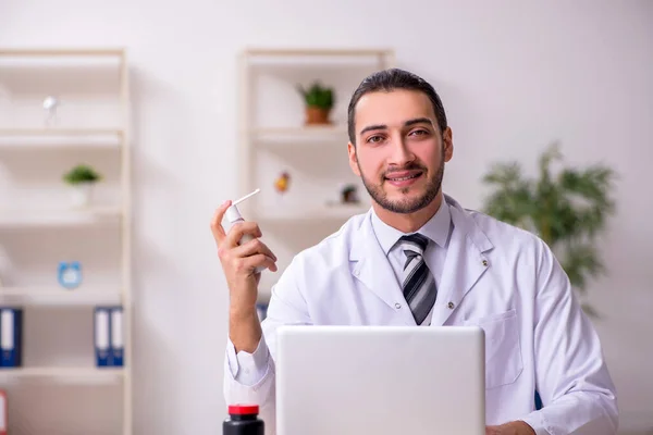 Ung manlig läkare som arbetar på kliniken — Stockfoto