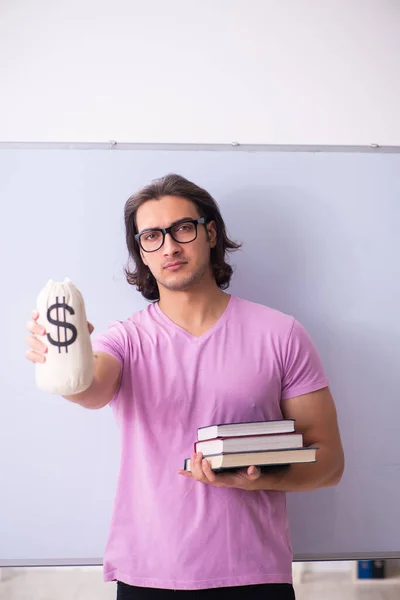 Young male student in front of board — Stock Photo, Image