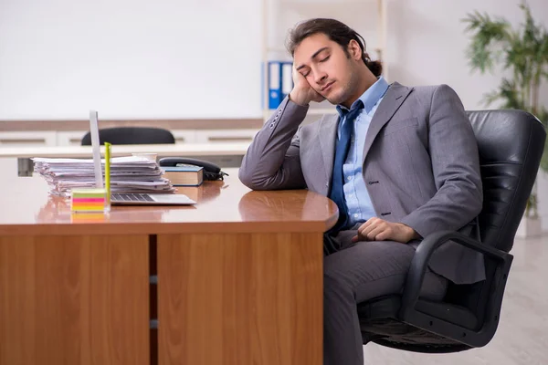 Mladý muž zaměstnanec spí v kanceláři — Stock fotografie