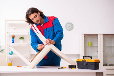 Genç erkek marangoz içeride çalışıyor.