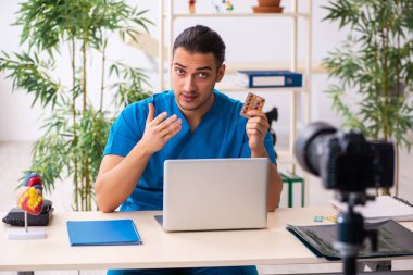 Genç erkek doktor blogu için video kaydediyor.