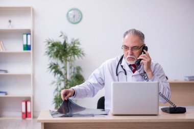 Klinikte çalışan yaşlı bir erkek radyolog.